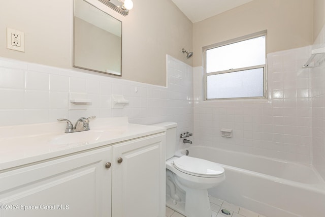 full bathroom with tile patterned floors, vanity, tile walls, toilet, and tiled shower / bath