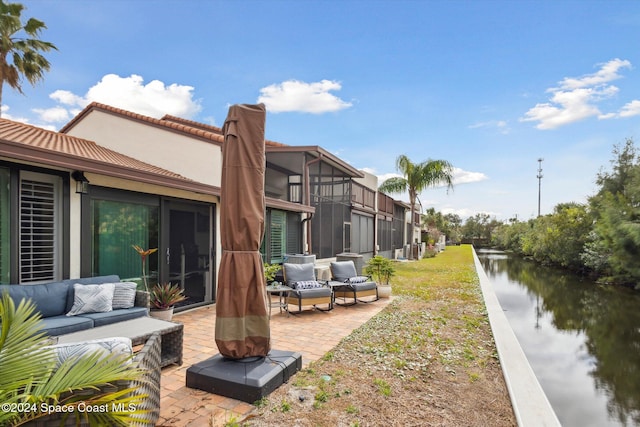 exterior space with outdoor lounge area, a water view, and a patio