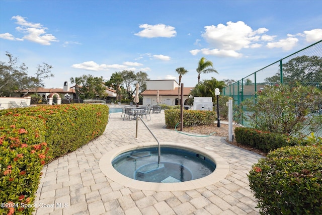 view of pool with a patio and a hot tub