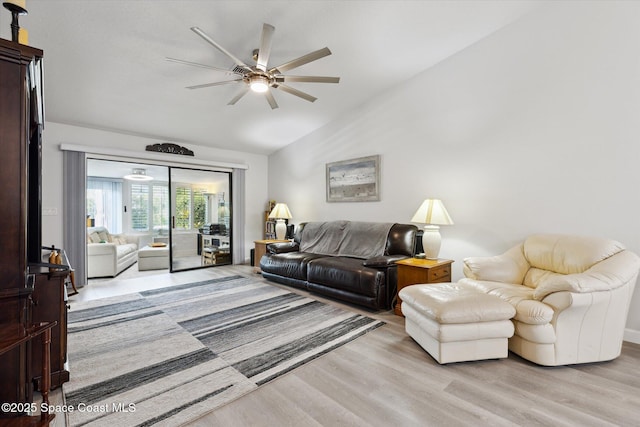 living room featuring ceiling fan, light hardwood / wood-style flooring, and vaulted ceiling