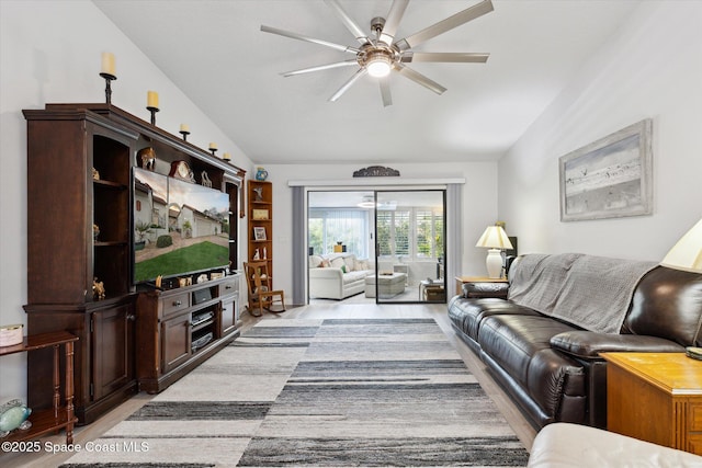 living room featuring ceiling fan, light hardwood / wood-style floors, and lofted ceiling