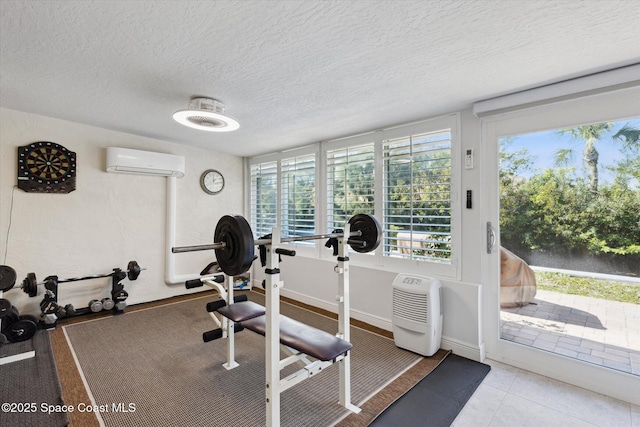 workout room featuring an AC wall unit and a textured ceiling