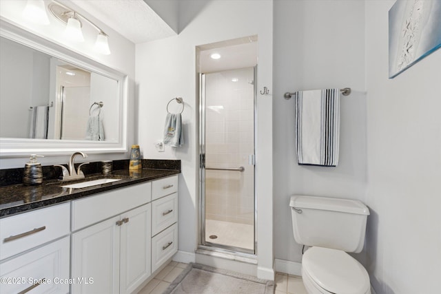 bathroom with toilet, tile patterned flooring, vanity, and walk in shower