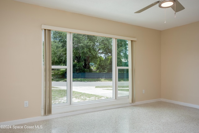 unfurnished room featuring ceiling fan and a wealth of natural light