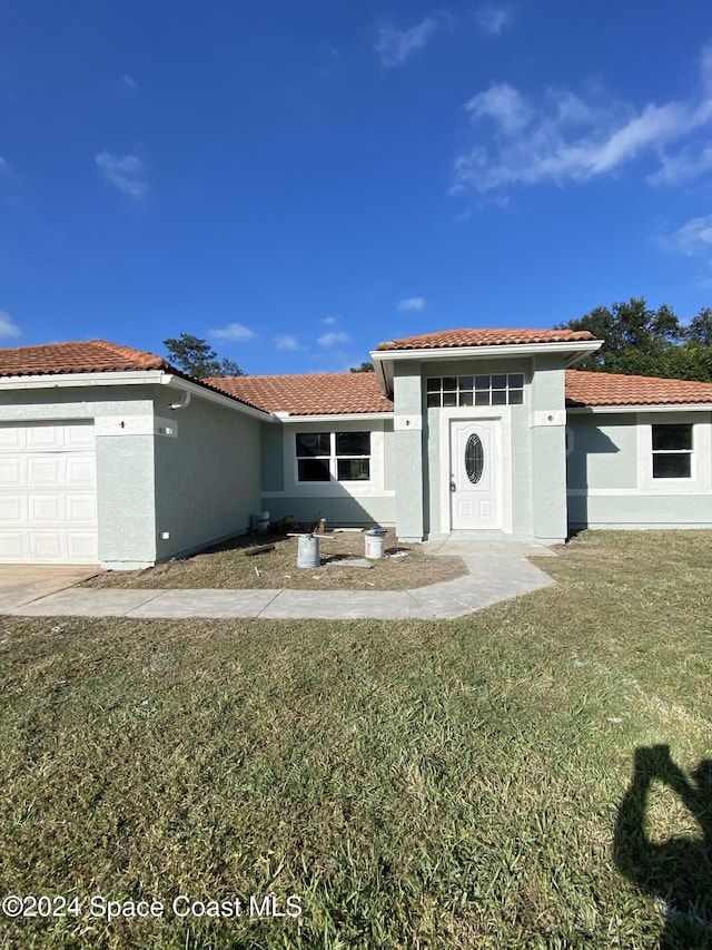 view of front of home featuring a garage and a front lawn