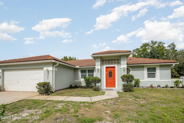 mediterranean / spanish house featuring a front yard, a tile roof, an attached garage, and stucco siding