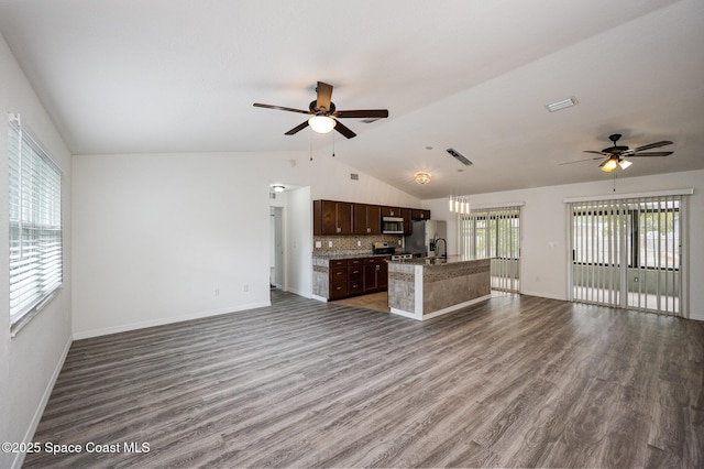 unfurnished living room featuring ceiling fan, visible vents, vaulted ceiling, and dark wood-type flooring