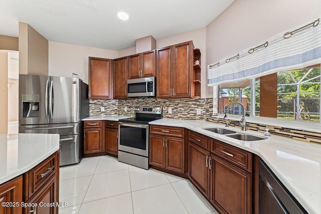 kitchen featuring backsplash, sink, light tile patterned flooring, and appliances with stainless steel finishes