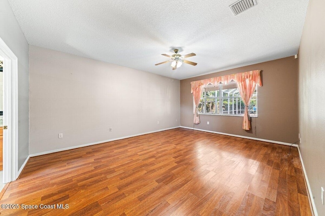 empty room featuring wood-type flooring, a textured ceiling, and ceiling fan