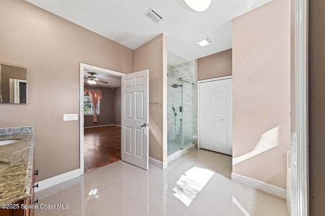 bathroom with tile patterned flooring, vanity, a shower with door, and ceiling fan