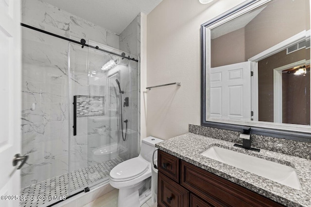 bathroom with vanity, toilet, and a shower with shower door