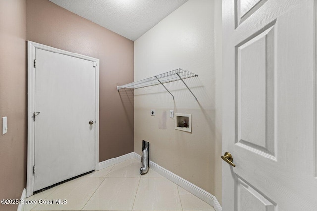 washroom featuring washer hookup, a textured ceiling, light tile patterned floors, and electric dryer hookup