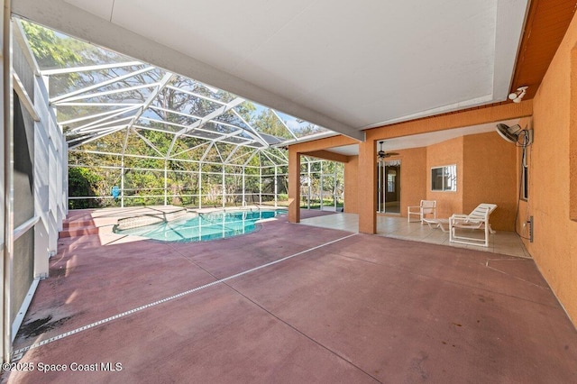 view of pool featuring glass enclosure and a patio