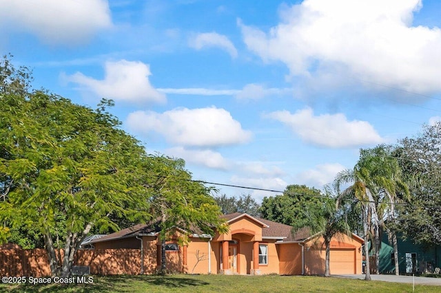 single story home featuring a front lawn and a garage