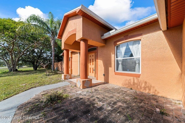 entrance to property featuring a yard