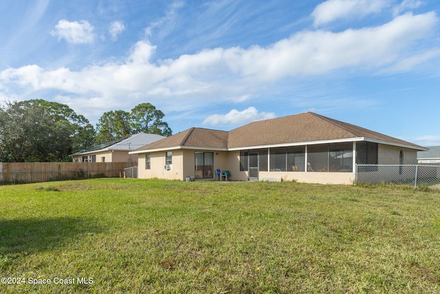 back of house with a yard and a sunroom