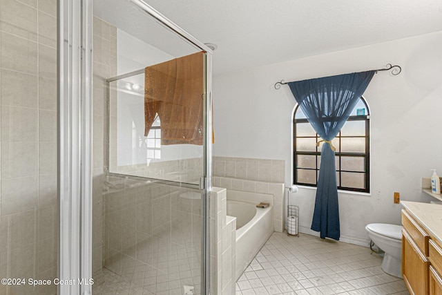 full bathroom featuring toilet, vanity, tile patterned floors, and separate shower and tub