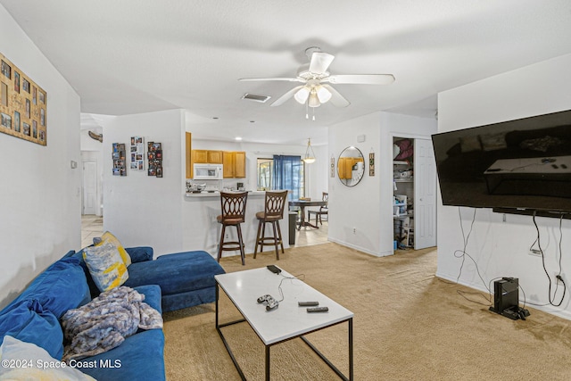 carpeted living room featuring ceiling fan