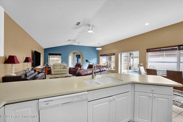 kitchen with lofted ceiling, white dishwasher, white cabinets, sink, and ceiling fan