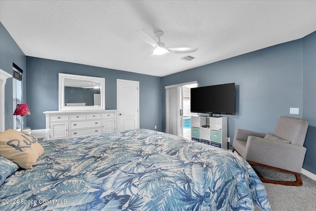 carpeted bedroom with a textured ceiling and ceiling fan