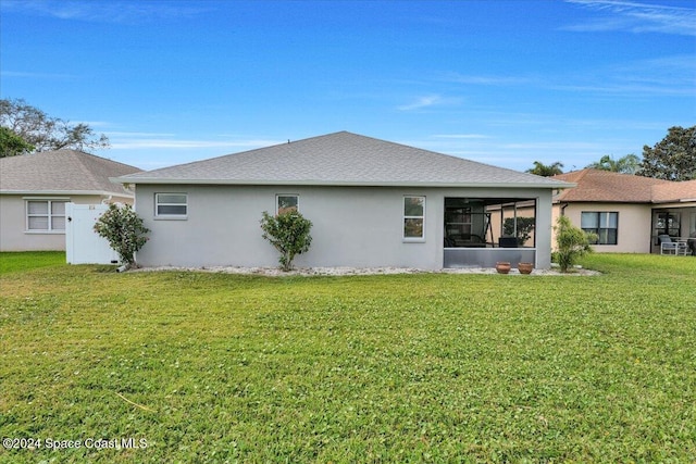 rear view of property featuring a yard