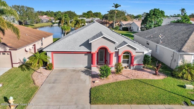 view of front facade with a front lawn, a water view, and a garage