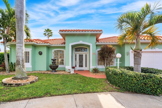 mediterranean / spanish house featuring a garage and a front lawn