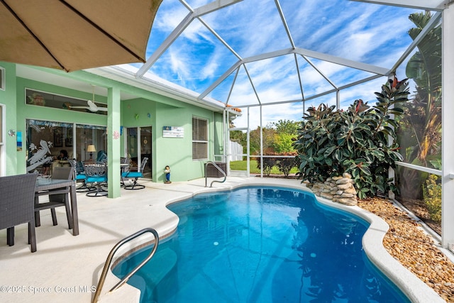 view of swimming pool with a lanai, ceiling fan, and a patio area