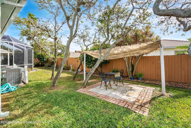 view of yard with cooling unit, a lanai, and a patio