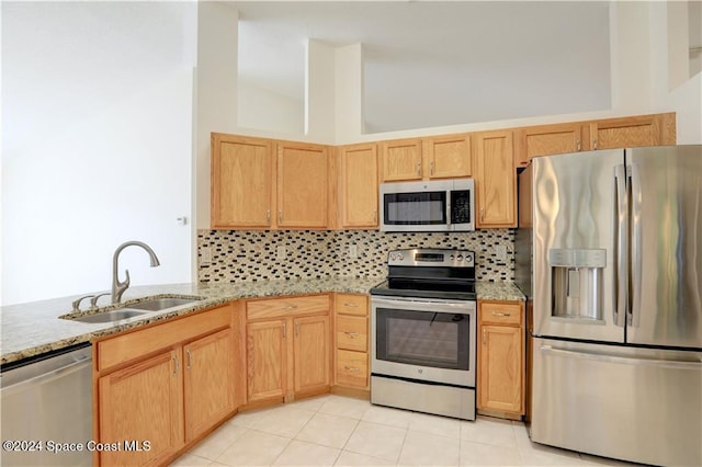 kitchen with backsplash, sink, light tile patterned floors, and stainless steel appliances