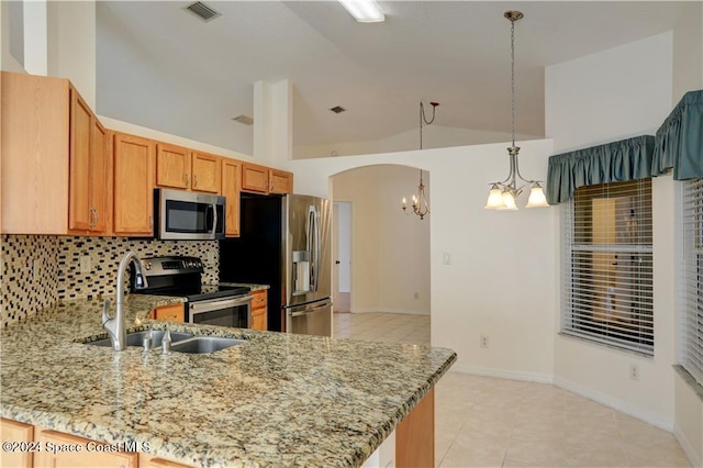 kitchen featuring kitchen peninsula, backsplash, stainless steel appliances, decorative light fixtures, and a notable chandelier