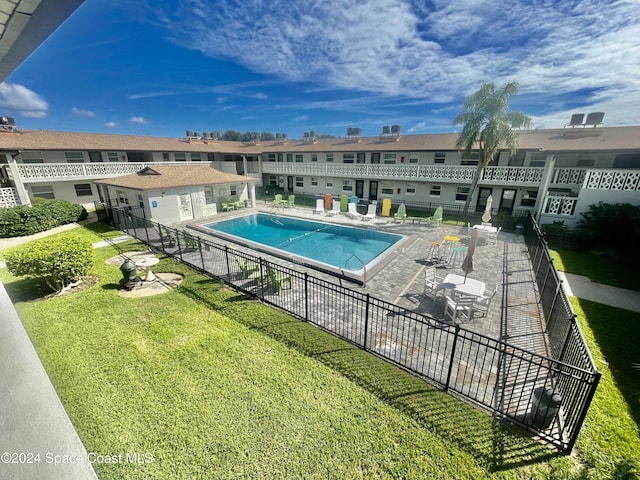 view of swimming pool featuring a patio area, a yard, and an outdoor structure