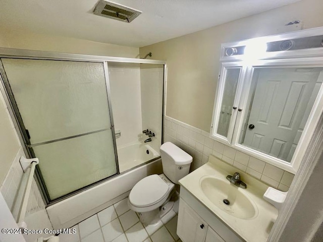 full bathroom with vanity, tile walls, enclosed tub / shower combo, tile patterned flooring, and toilet