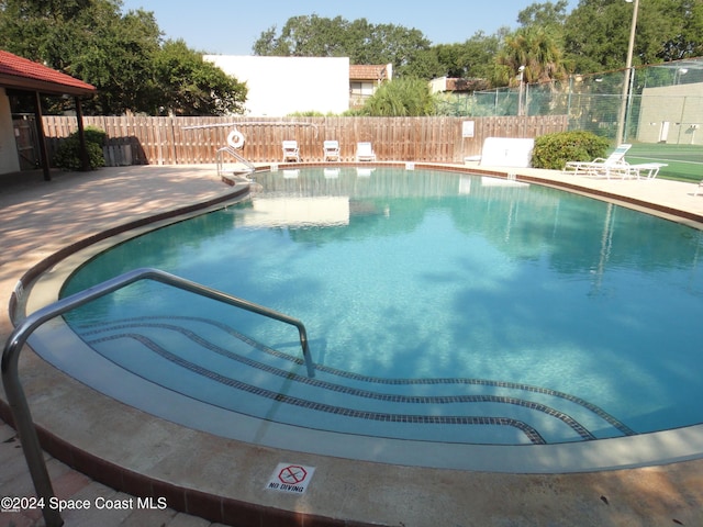 community pool featuring a patio and fence