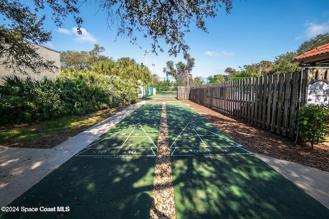 view of home's community with shuffleboard and fence