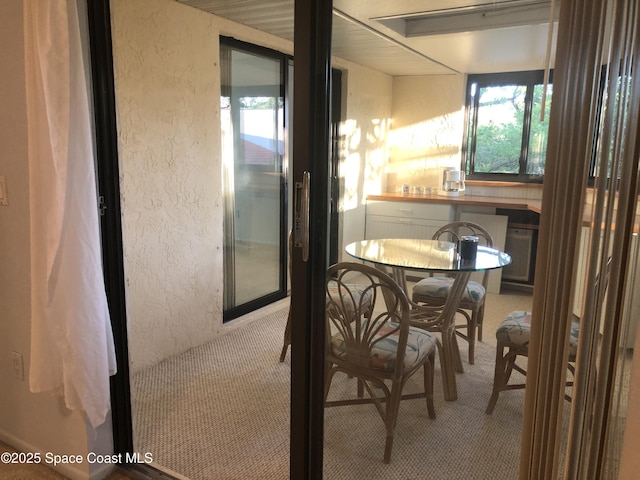 dining room with carpet flooring and a textured wall