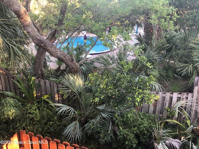 view of swimming pool featuring fence