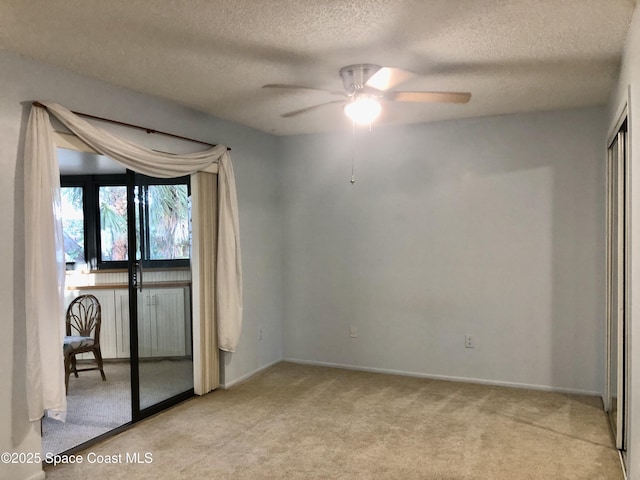 unfurnished bedroom featuring ceiling fan, a textured ceiling, baseboards, and carpet floors