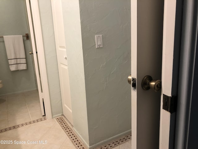 bathroom with tile patterned floors, toilet, and baseboards