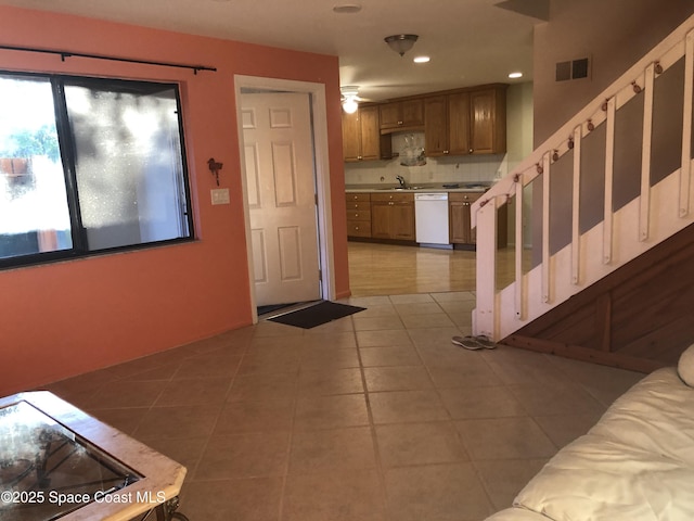 interior space featuring visible vents, light countertops, decorative backsplash, white dishwasher, and tile patterned floors