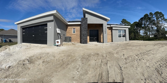 view of front of property featuring central AC unit and a garage