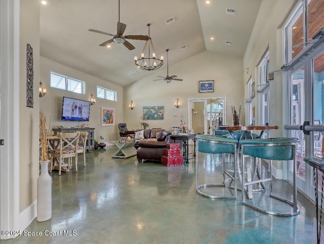 living room featuring ceiling fan with notable chandelier, french doors, high vaulted ceiling, and concrete floors