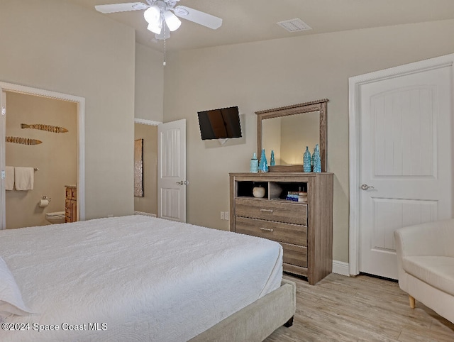 bedroom with connected bathroom, ceiling fan, light hardwood / wood-style flooring, and lofted ceiling