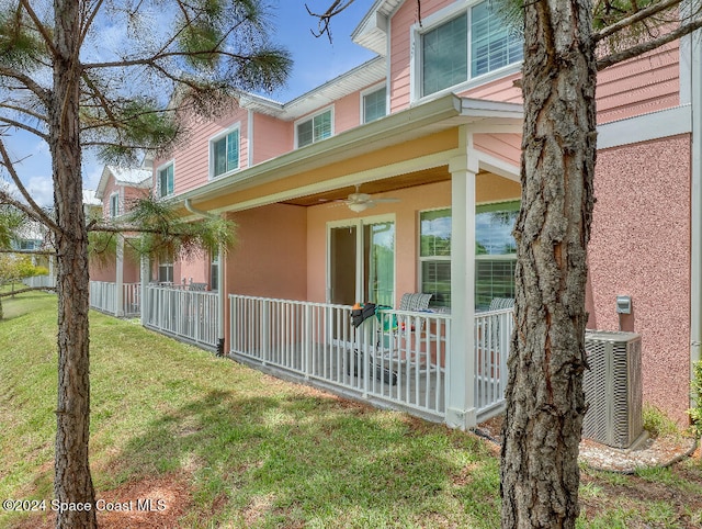 view of side of property featuring central AC, ceiling fan, a yard, and a porch