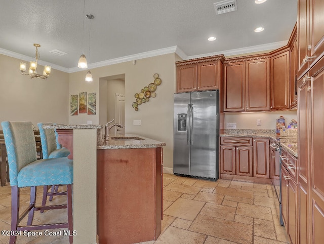 kitchen with pendant lighting, stainless steel fridge, crown molding, and sink