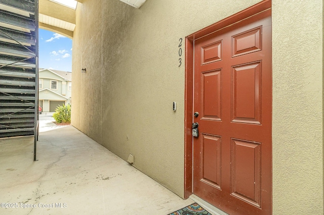 entrance to property featuring stucco siding