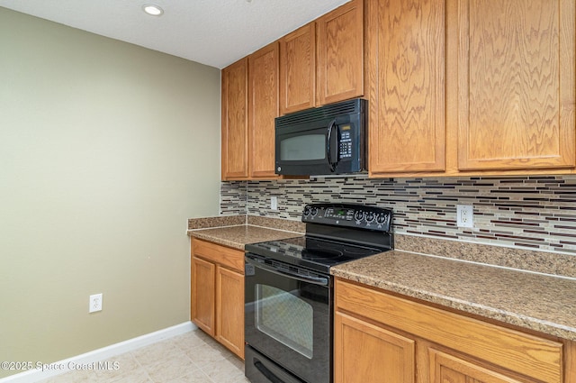 kitchen with light tile patterned floors, backsplash, brown cabinetry, black appliances, and baseboards