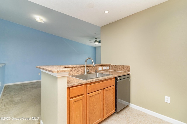 kitchen featuring a peninsula, dishwasher, baseboards, and a sink