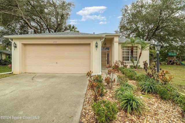 single story home with stucco siding, concrete driveway, a playground, and a garage