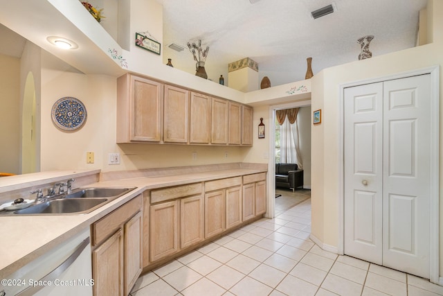 kitchen with sink, light tile patterned flooring, white dishwasher, and light brown cabinets